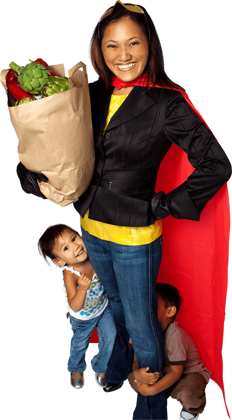 Woman wearing superhero cape holding bag a groceries with a child holding on to her leg